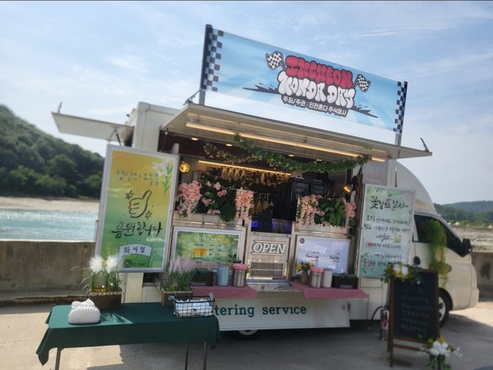 야외 케이터링 현장의 푸드트럭과 디저트 테이블